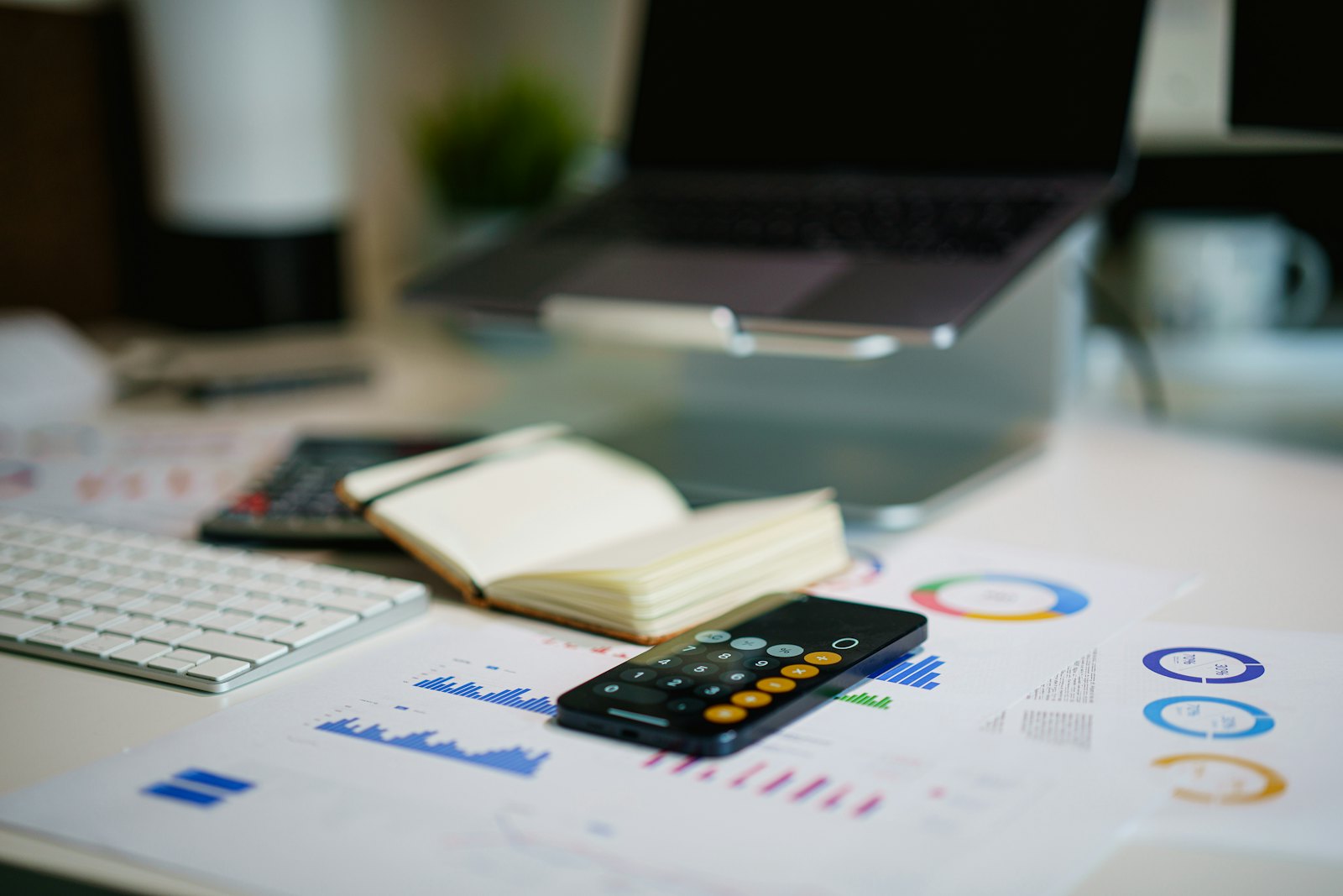 Financial charts and a phone on an office desk